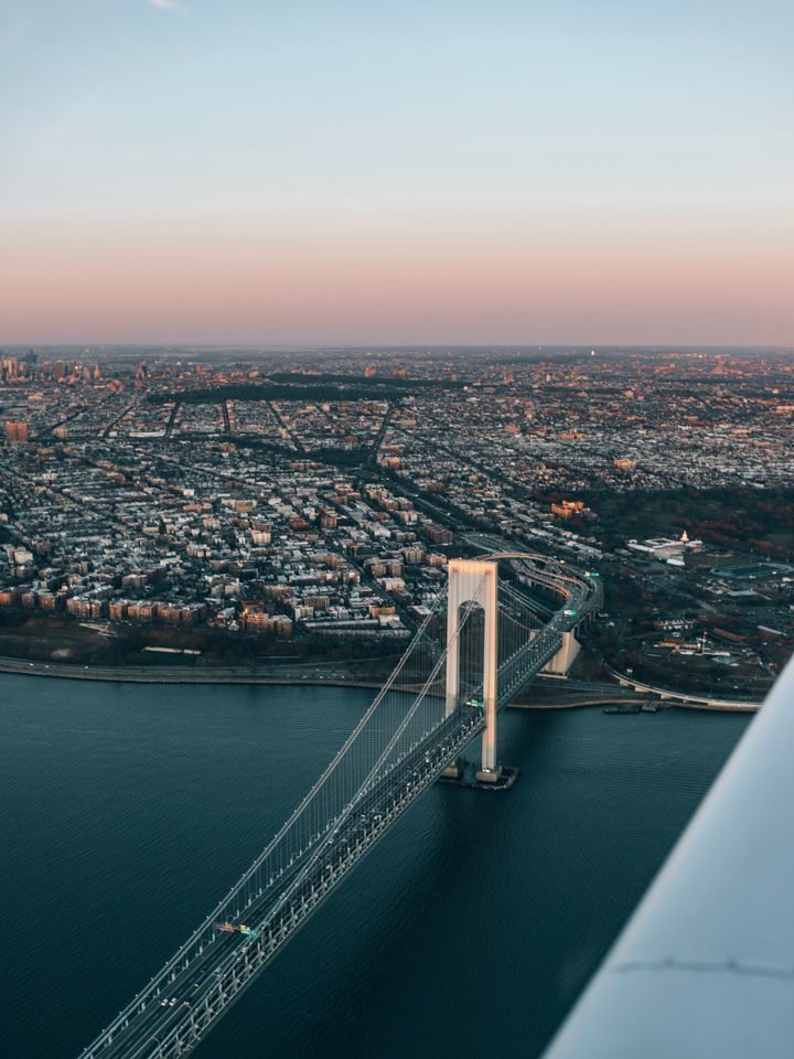 The Verrazzano-Narrows Bridge and Brooklyn seen past the wing of the aircraft